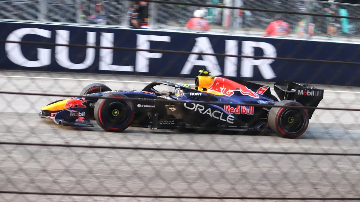 La Red Bull RB22 n° 6 d'Isack Hadjar en course, vue à travers un grillage, lors du Grand Prix de Bahreïn 2026