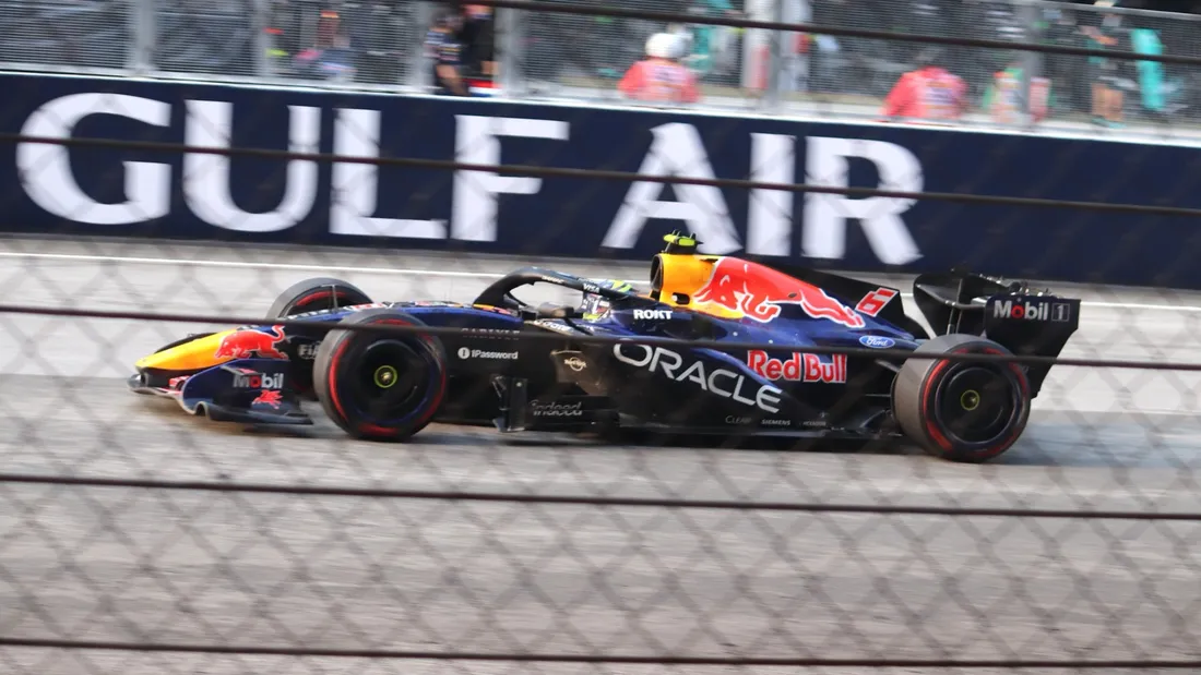 La Red Bull RB22 n° 6 d'Isack Hadjar en course, vue à travers un grillage, lors du Grand Prix de Bahreïn 2026