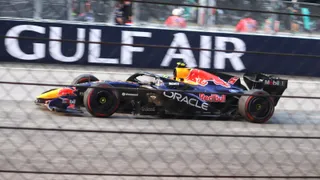 La Red Bull RB22 n° 6 d'Isack Hadjar en course, vue à travers un grillage, lors du Grand Prix de Bahreïn 2026