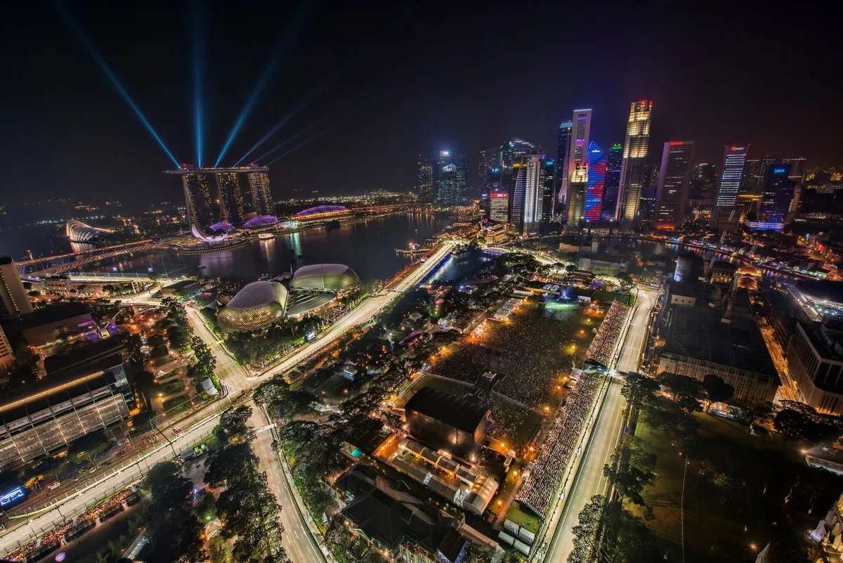 Vue aérienne de nuit du circuit urbain de Marina Bay à Singapour, avec les gratte-ciel et la foule du Grand Prix