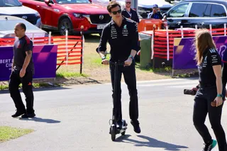 Toto Wolff, en tenue Mercedes, se déplaçant en trottinette dans le paddock du Grand Prix d'Australie 2026